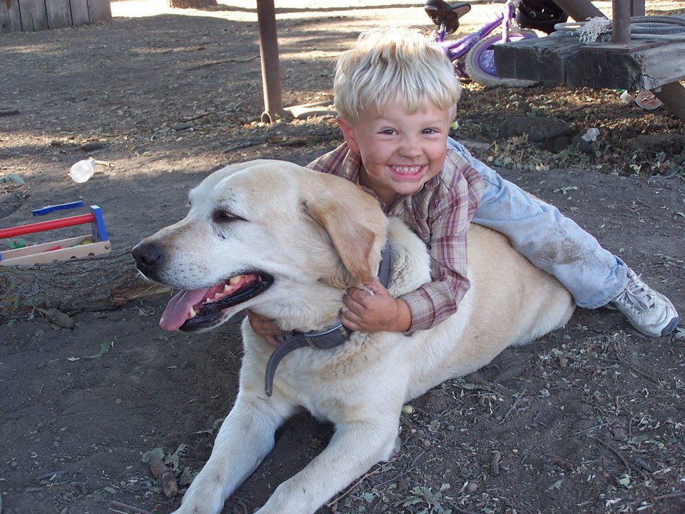 A boy and his dog are smiling for the camera.