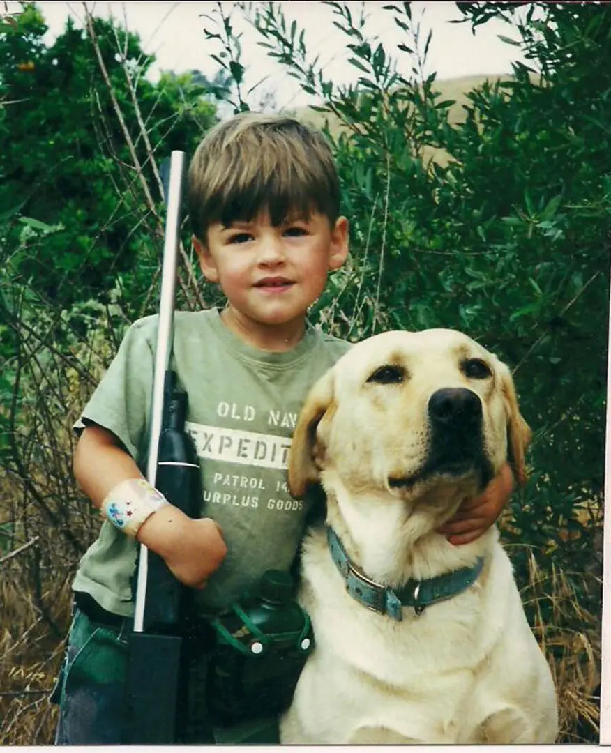 A boy and his dog are posing for the camera.